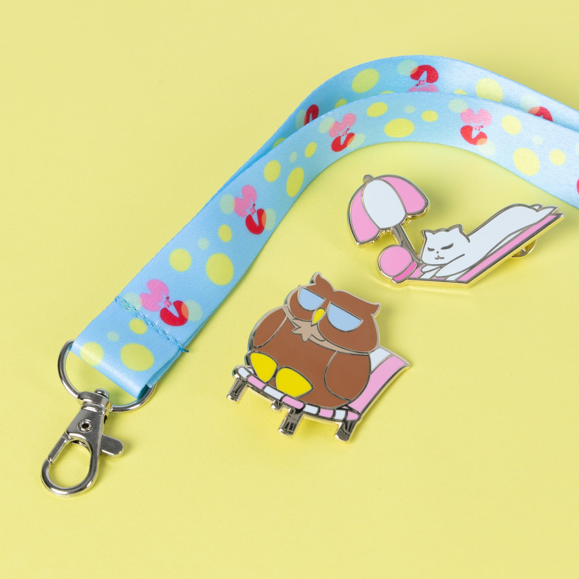 Photograph of Cute Mars N' Venus (MnV) summer logo lanyard; displayed alongside our summer Catstronaut and Professor Hoots hard enamel pins.